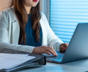 Frau sitzt vor dem Laptop und checkt E-Mails