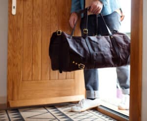 Mann mit Tasche tritt durch eine Tür