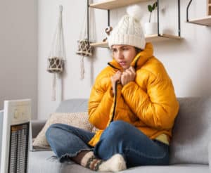 Frau friert in der Wohnung