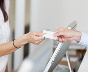 Mann überreicht Krankenversichertenkarte