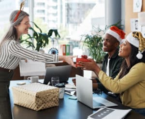 arbeitnehmer-mit-weihnachtsmützen-beschenken-sich-im-büro