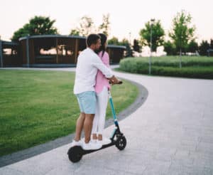 paar-fährt-auf-elektroroller-durch-park
