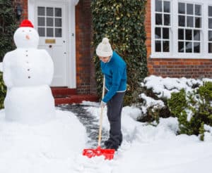 Frau schippt Schnee