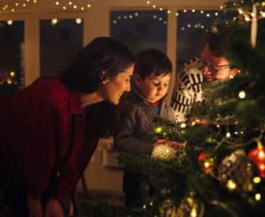 Familie steht um den Weihnachtsbaum