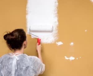 frau-streicht-beige-wand-weiß