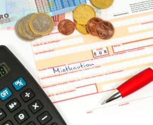 überweisungszettel-für-mietkaution-neben-taschenrechner